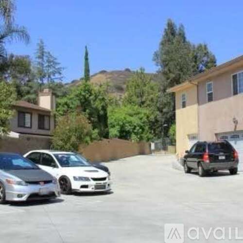 Two cars parked in a driveway in front of a house.