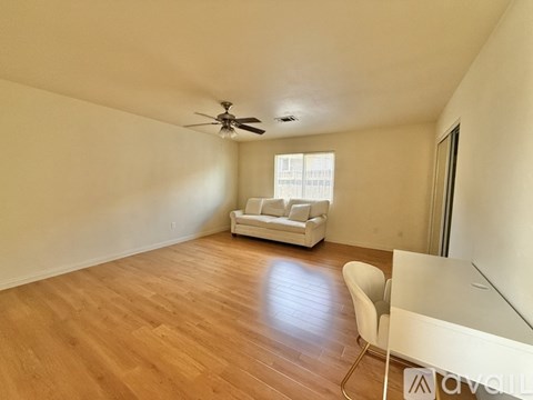 A living room with a white couch and a ceiling fan.