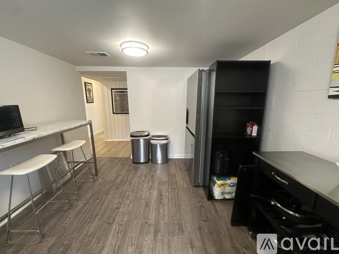 A kitchen with a refrigerator, stove, and bar stools.