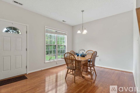 A dining room with a wooden table and chairs.