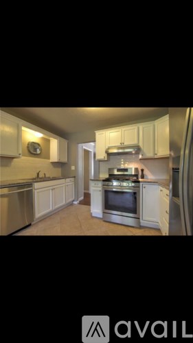 A kitchen with white cabinets and a stainless steel dishwasher.