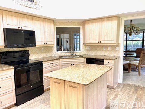 A kitchen with wooden cabinets and a granite countertop.