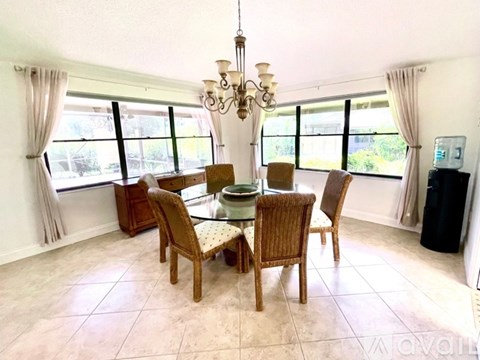 A dining room with a table and chairs.
