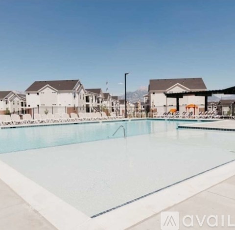 A large swimming pool in front of a row of houses.