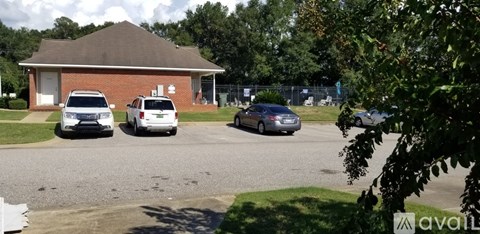 A parking lot with cars and a building in the background.