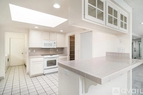 A kitchen with white cabinets and appliances.