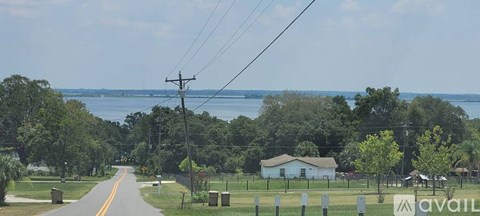 A road with a house and trees on the side.