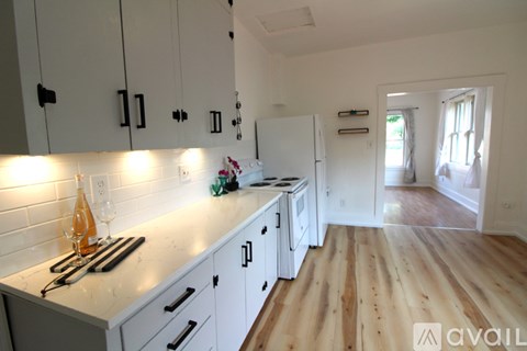 A kitchen with white cabinets and a white fridge.