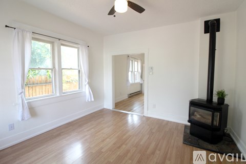 A living room with a wood burning stove and a fan.