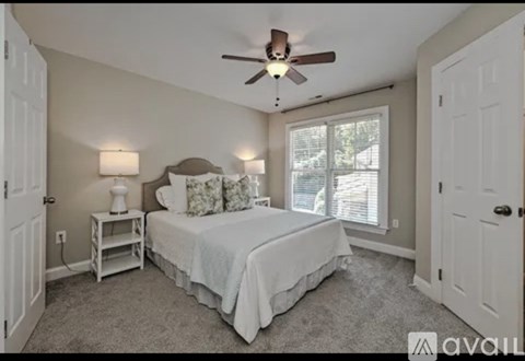 A bedroom with a bed, nightstand, and window.