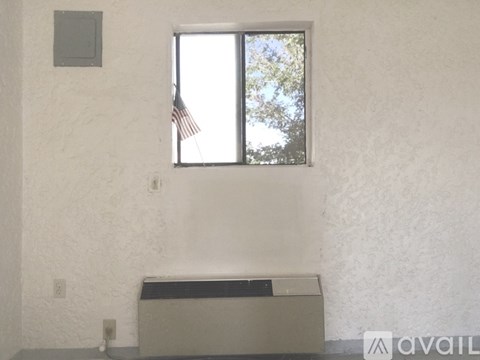 A room with a window and a wall-mounted air conditioner unit.
