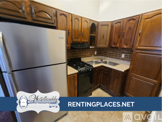 A kitchen with wooden cabinets and a stainless steel refrigerator.