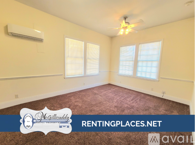 A room with a carpeted floor, a ceiling fan, and a window with blinds.