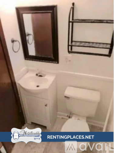 A white toilet and sink in a small bathroom.