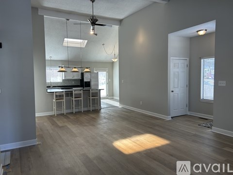 A spacious room with a kitchenette and a dining table.