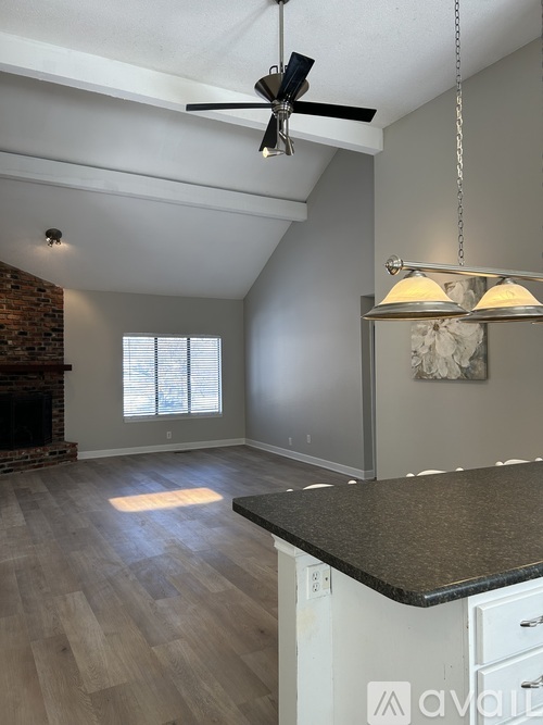 A room with a ceiling fan and a fireplace.