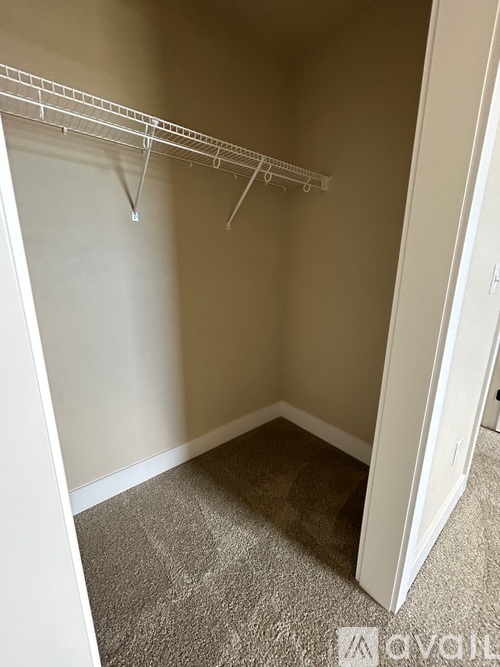Empty room with a white door and a white clothes rack.