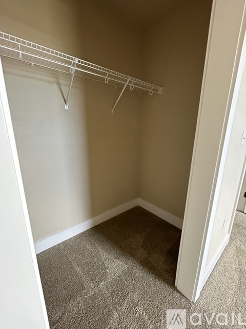 Empty room with a white door and a white clothes rack.