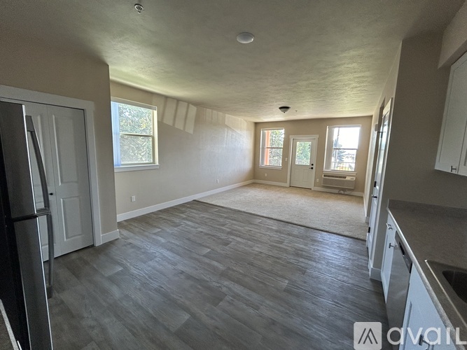 A kitchen with a refrigerator, cabinets, and a countertop.