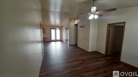A room with wooden floors and a ceiling fan.