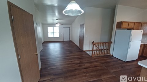 A room with wooden floors and a white refrigerator.