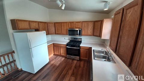 A kitchen with wooden cabinets and a white fridge.