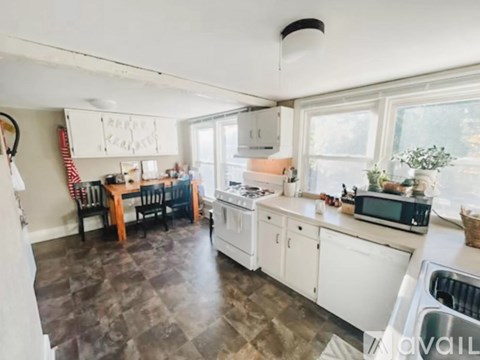 A kitchen with white cabinets and a darker floor.