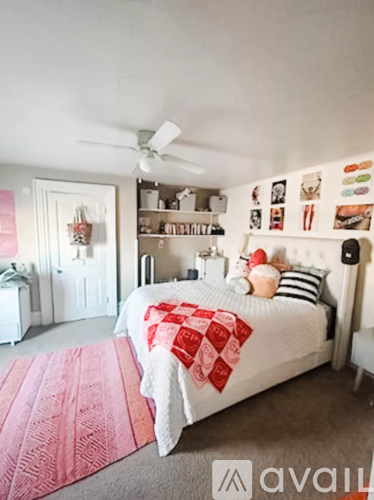 A bedroom with a bed covered in a red and white blanket.