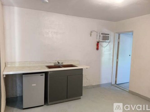 A kitchen area with a white countertop and grey cabinets.