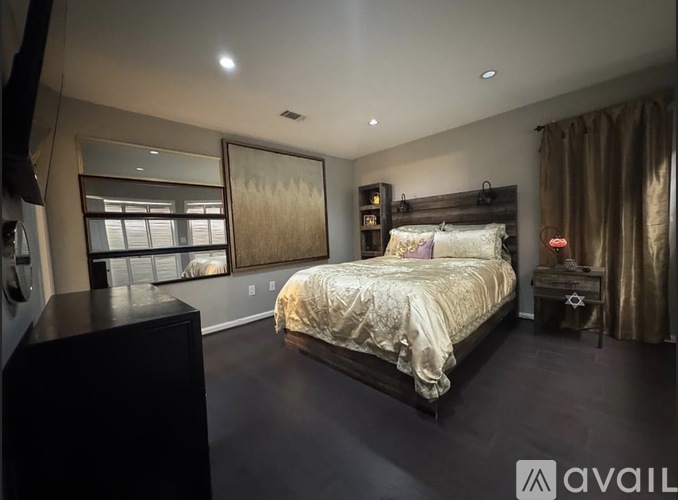 A bedroom with a large bed and a large window.