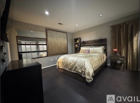 A bedroom with a large bed and a large window.
