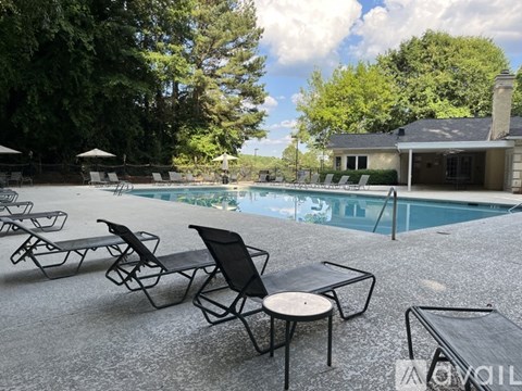 A poolside area with chairs and tables.