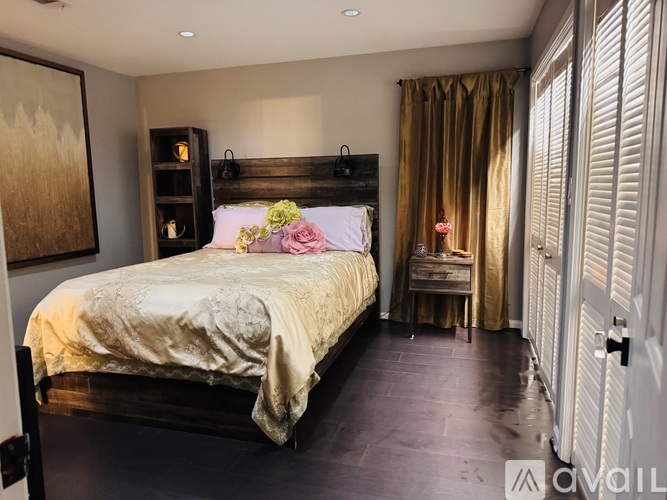 A bedroom with a bed, a nightstand, and a chair.
