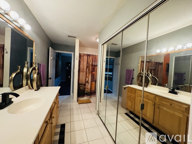 A bathroom with a sink, mirror, and shower.