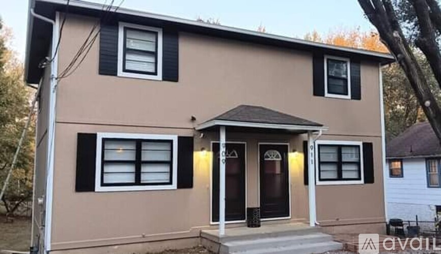 A house with a brown front and black shutters is for sale.