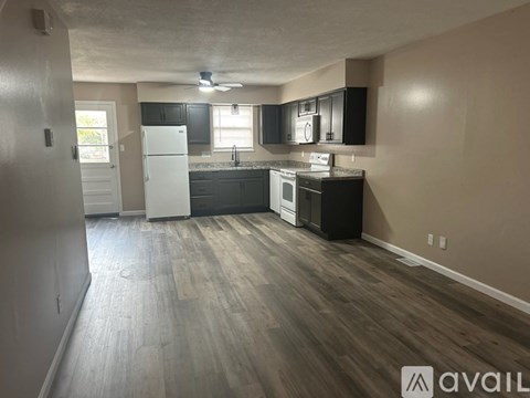 A kitchen with a white refrigerator and black cabinets.