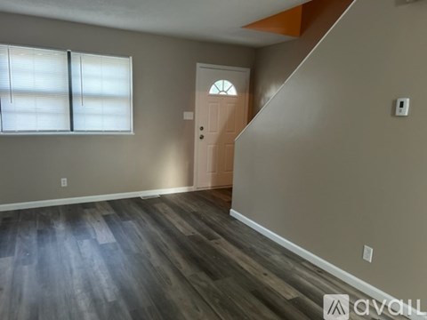 A room with wooden flooring and a white door.