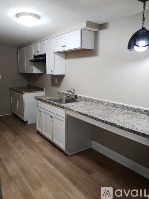 A kitchen with white cabinets and a granite countertop.