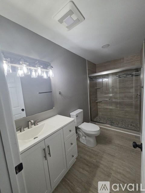 A bathroom with a sink, toilet, and shower.