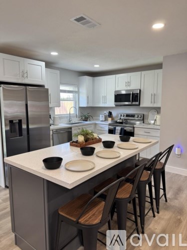 A modern kitchen with a dining table set for two.