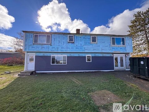 A blue house with a white door and windows is for sale.