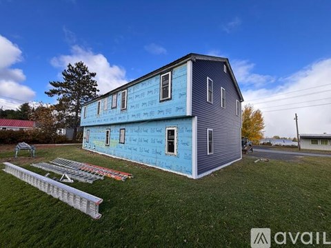 A blue house with a white fence in front of it.
