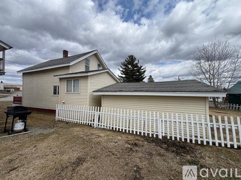 A house with a white picket fence in front of it.