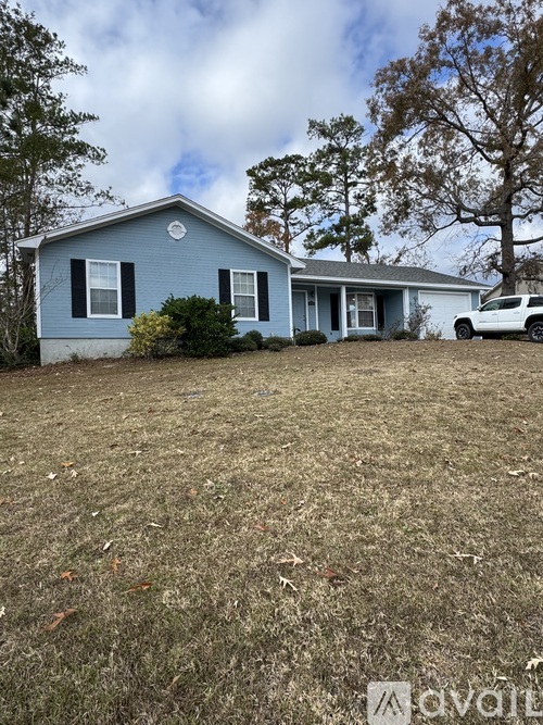 A blue house with a white car parked in front.