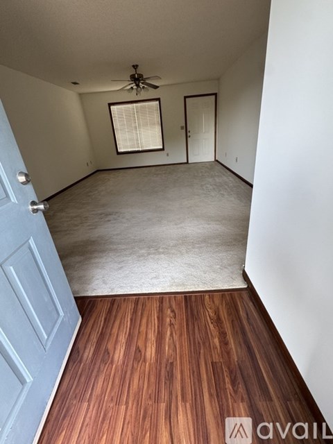 A room with a wooden floor and a ceiling fan.