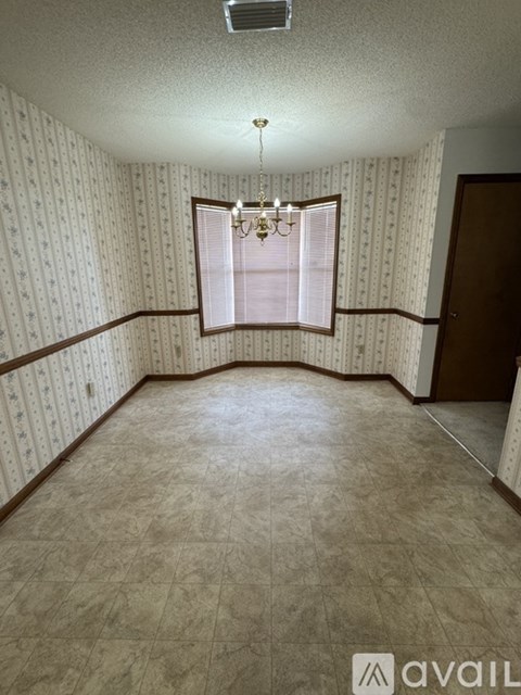 A room with a window and a chandelier.