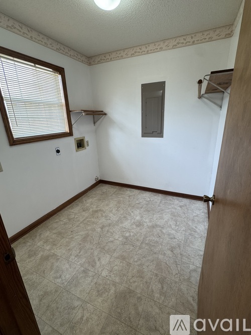 A room with a window, a shelf, and a light switch.