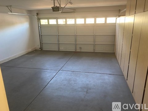 A spacious garage with a concrete floor and a white wall.