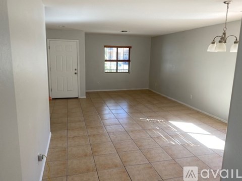A room with a door, a window, and a tiled floor.