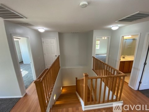 A well-lit, empty living space with a staircase leading to the upper level.